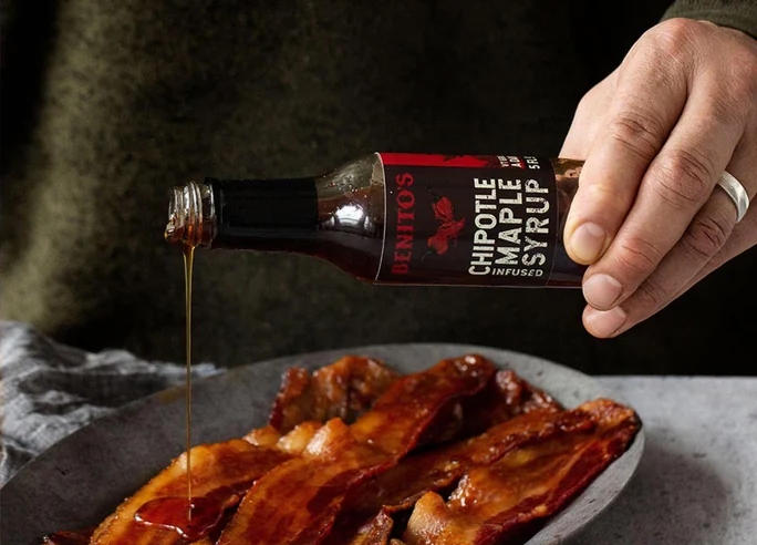 Benito's chipotle infused maple syrup poured onto a plate of bacon